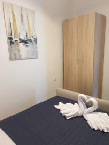 a bedroom with a bed with swan towels on it at Apartman_trile in Ulcinj