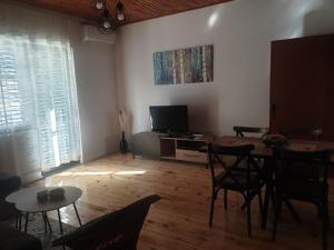 a living room with a table and chairs and a television at Apartman_trile in Ulcinj