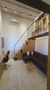 a living room with a couch and a stair case at Tinos Retreat, Architect's Guest House in Tinos Town
