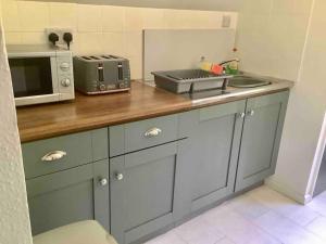 cocina con encimera y microondas en Self Catering Apartment, Jurassic Coast/Dorset en Wareham