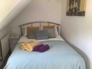 1 cama con 2 mantas y almohadas en Self Catering Apartment, Jurassic Coast/Dorset, en Wareham