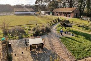 a man is sitting at a table in a yard at Self Catering Apartment, Jurassic Coast/Dorset in Wareham +12 photos