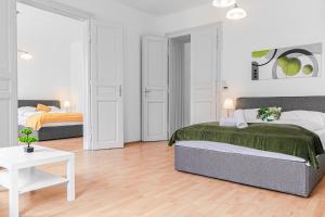 ein weißes Schlafzimmer mit 2 Betten und einem Tisch in der Unterkunft Pleasing 2BR Apt. AKH-Perfect for Groups in Wien