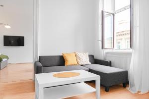 ein Wohnzimmer mit einem Sofa und einem Tisch in der Unterkunft Pleasing 2BR Apt. AKH-Perfect for Groups in Wien