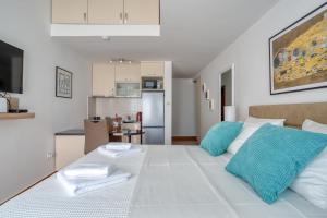 um quarto com uma cama branca e almofadas azuis em Apartment Elegant em Kotor