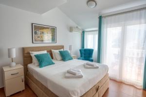 um quarto com uma cama grande e uma cadeira azul em Apartment Elegant em Kotor