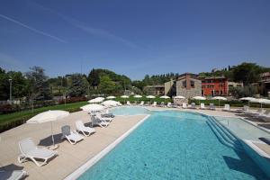 a large swimming pool with chairs and umbrellas at Residence Borgo Mondragon in Lazise