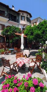 a patio with a table and chairs and flowers at Villa Sunray in Agios Ioannis Pelio