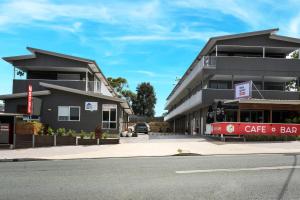 a building on the corner of a street with a cafe bar at Petrie Mill Motel in Petrie