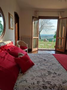 a bedroom with a large bed and a large window at Villa Pieve in Moncalvo