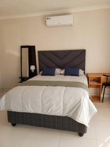 1 dormitorio con 1 cama grande con almohadas azules en Kasuda - self contained room in Livingstone en Livingstone