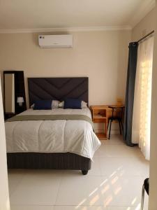 a bedroom with a large bed with blue pillows at Kasuda - self contained room in Livingstone in Livingstone