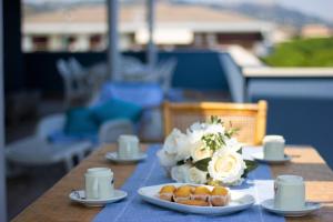 einen Tisch mit Teller mit Lebensmitteln und Blumen darauf in der Unterkunft Temporary Home Silvi 3 in Silvi Marina