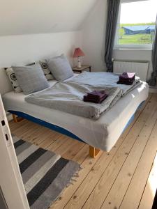 a large bed in a bedroom with a wooden floor at Jægergård in Skærbæk
