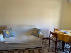 salon z białą kanapą i stołem w obiekcie Casa Maria Costa Blu w mieście Isola delle Femmine