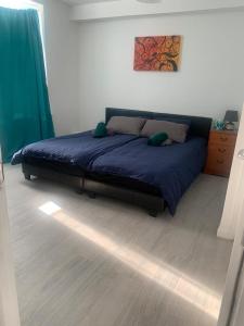 um quarto com uma cama com um edredão azul em Lovely 5 Bedroom Home in Dagenham London em Goodmayes