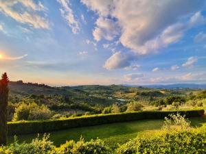 a view of a green field with the sunset in the background at Residenza Il Colle in Impruneta