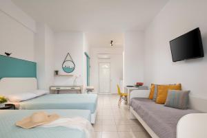 a hotel room with two beds and a tv at Kochyli Beach Studios in Nea Plagia