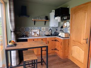 a kitchen with a wooden table and a counter top at Coral Cabins in Dunvegan