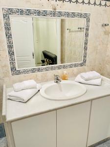 W łazience znajduje się biała umywalka i lustro. w obiekcie Chryssa’s Studios Deluxe (5 visitors) A2 w mieście Patras