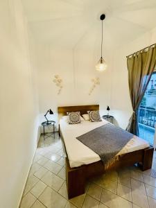 sypialnia z łóżkiem i dużym oknem w obiekcie Chryssa’s Studios Deluxe (5 visitors) A2 w mieście Patras