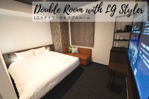 a hotel room with a bed and a tv at Henn na Hotel Tokyo Akasaka in Tokyo