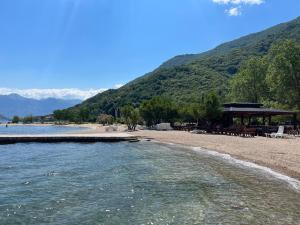 - une plage avec un kiosque et une étendue d'eau dans l'établissement Apartment "Two Sisters" with a sea view, à Donji Morinj