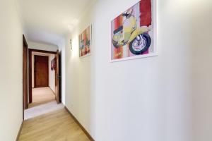 a hallway with paintings of a motorcycle on the wall at Apartment Colosseo in Rome