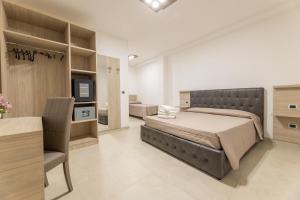 Schlafzimmer mit einem Bett, einem Schreibtisch und einem TV in der Unterkunft Room Salento Palace 2 in Torre San Giovanni Ugento
