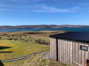 a wooden building with a view of a body of water at Coral Cabins in Dunvegan