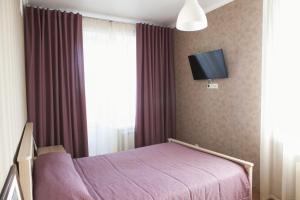 a bedroom with a purple bed and a tv at Апартаменты на Спортивной in Tolyatti