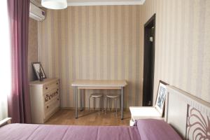 a bedroom with a table and a bed and a dresser at Апартаменты на Спортивной in Tolyatti