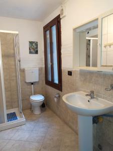 ein Badezimmer mit einem Waschbecken, einem WC und einem Spiegel in der Unterkunft CANAL VIEW in Venedig