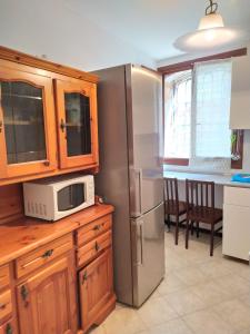 eine Küche mit einem Kühlschrank aus Edelstahl und einer Mikrowelle in der Unterkunft CANAL VIEW in Venedig