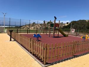 a playground with a slide on top of a red carpet at São Torpes by Campigir in Sines