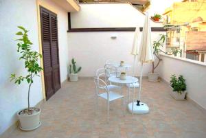 a patio with a table and chairs and an umbrella at B&B Flavilla in Santa Flavia