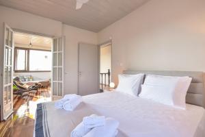 a bedroom with a large white bed with towels on it at ALEXANDRE MAISON Beachfront Gialova Vacation Home in Gialova