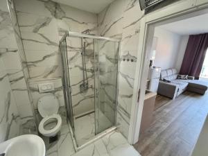 un bagno con wc e doccia in vetro di Apartments GC 3 a Rafailovici Altre 21 foto