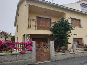 a house with pink flowers in front of it at Casa Regina in O Grove