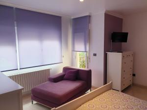 een woonkamer met een paarse bank en een dressoir bij Casa Regina in O Grove