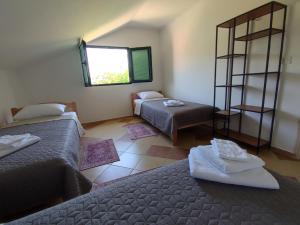 Un dormitorio con dos camas y una ventana. en Montenegro Colors Kamenari, en Kamenari