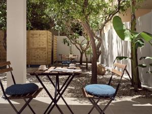 a table and chairs in a courtyard with trees at Margie City Apartment in Zakynthos