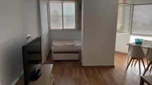 um pequeno quarto com uma cama e uma mesa em Estudio cerca de la playa 3 em Málaga