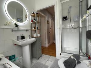 a white bathroom with a sink and a shower at Lovely apartment in Cork in Cork