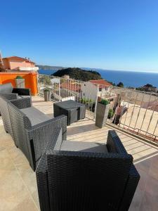 una fila de sillas y mesas en un patio con vistas al océano en Guest House Bellavista Nebida, en Nebida 78 fotos más