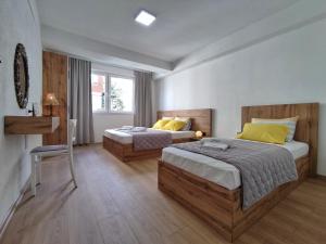 a bedroom with two beds and a chair in it at Marko's Apartment in Ohrid
