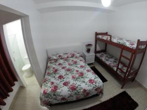 Dormitorio pequeño con cama y estante en Morada da Lena 1, en Balneário Camboriú