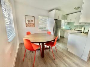 una cucina con tavolo in legno e sedie arancioni di Casa MIA central location, free parking, fully equipped a Miami
