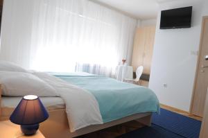 sypialnia z łóżkiem z lampką i oknem w obiekcie Rooms Stella w mieście Sesvete