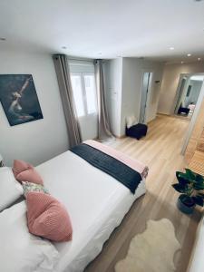 1 dormitorio con 1 cama blanca grande con almohadas en Fantastic Apartment City Center - Optional Parking en Málaga